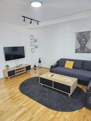 a living room with a blue couch and a coffee table at N&M Apartment in Pirot