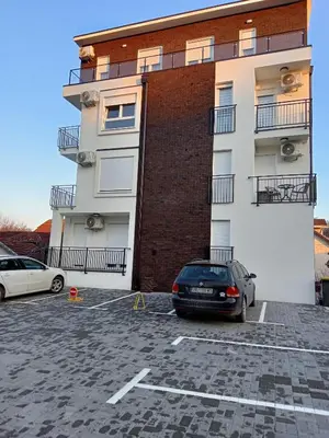 a car parked in a parking lot in front of a building at Apartman '' PETICA'' in Vrnjačka Banja