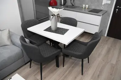 a dining room table with chairs and a vase on it at RELAX LUX AKVA PARK(K-KOMPLEX) in Jagodina