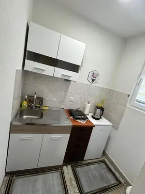 a small kitchen with a sink and white cabinets at Apartman i Studio Nikolas in Soko Banja