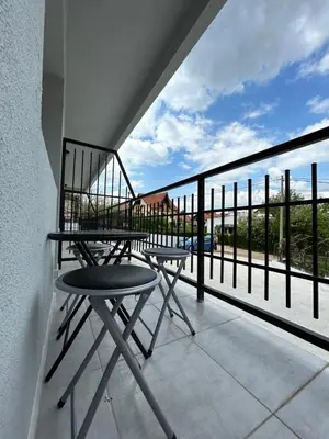 a chair on a balcony with a view of the ocean at Apartman i Studio Nikolas in Soko Banja