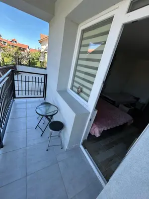 a balcony with a window and a table and a chair at Apartman i Studio Nikolas in Soko Banja