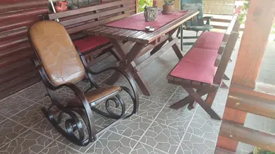 a chair and a wooden table and bench on a patio at Holiday Home Di More in Jagodina