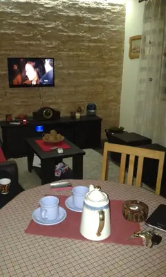 a room with a table and a tv and a table with cups at Holiday Home Di More in Jagodina