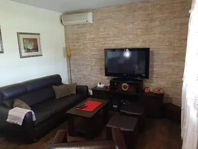 a living room with a couch and a flat screen tv at Holiday Home Di More in Jagodina