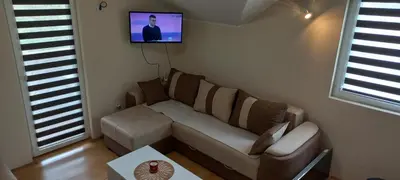 a living room with a couch and a tv on the wall at Studio Isidora in Vrnjačka Banja