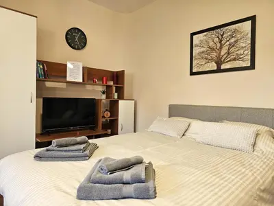 a bedroom with a bed with towels on it at Apartmani TRIO in Vrnjačka Banja