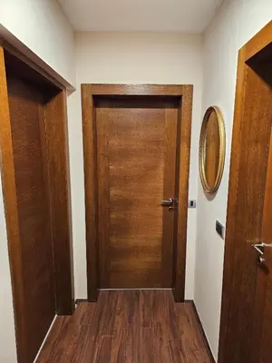 a corridor with a wooden door in a room at Apartmani TRIO in Vrnjačka Banja