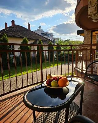a bowl of fruit on a table on a balcony at Apartmani TRIO in Vrnjačka Banja