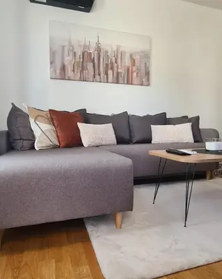 a living room with a couch and a table at Iskra Sparkle apartman in Soko Banja