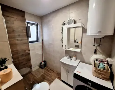 a bathroom with a sink and a toilet and a mirror at Iskra Sparkle apartman in Soko Banja