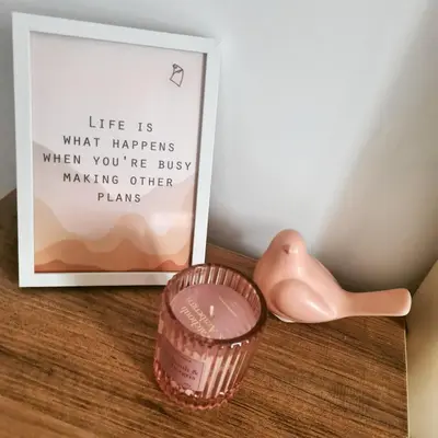 a container of pink lipstick sitting next to a picture at Iskra Sparkle apartman in Soko Banja