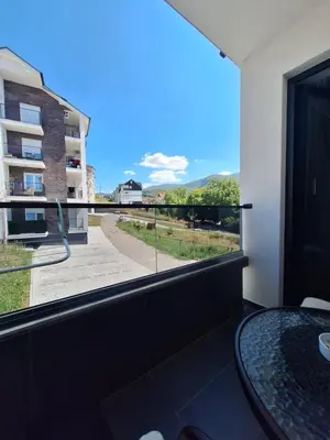 a room with a large window with a table and a view at Iskra Sparkle apartman in Soko Banja