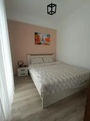 a bedroom with a bed and a painting on the wall at Apartman Zara - free private parking - in Jagodina
