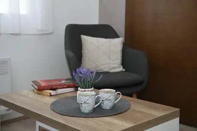 two coffee cups on a wooden table with a chair at Apartman Zara - free private parking - in Jagodina