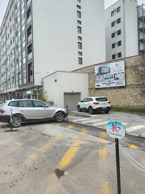 two cars parked in a parking lot next to buildings at Apartman Zara - free private parking - in Jagodina