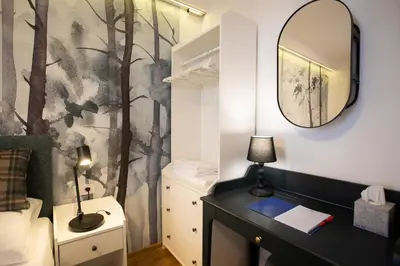 a bedroom with a black desk and a mirror at Cardak u Sumi (Forest house) in Kopaonik