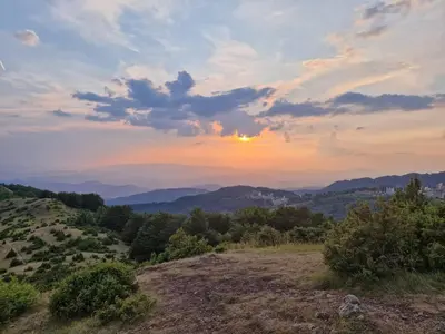 a sunset on a hill with a view of the mountains at Cardak u Sumi (Forest house) in Kopaonik
