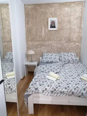 a small bedroom with a bed and a mirror at Panorama in Vrnjačka Banja