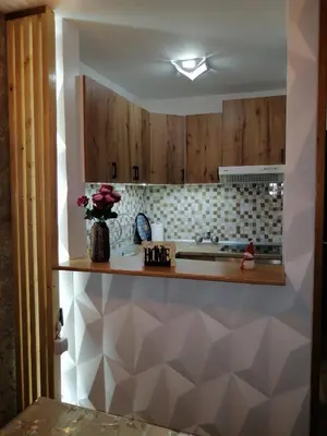 a kitchen with wooden cabinets and a counter top at Panorama in Vrnjačka Banja