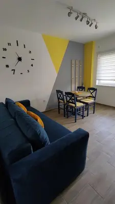a living room with a couch and a clock on the wall at Apartman 2 Miljković in Soko Banja