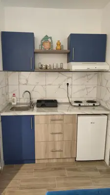 a kitchen with blue cabinets and a sink at Apartman 2 Miljković in Soko Banja