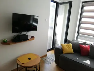 a living room with a couch and a flat screen tv at Mali Raj in Soko Banja