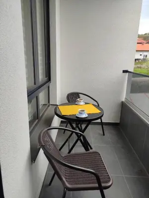 a small table and two chairs on a balcony at Mali Raj in Soko Banja