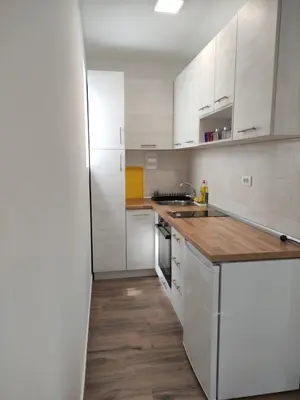 a kitchen with white cabinets and a wooden counter top at Mali Raj in Soko Banja