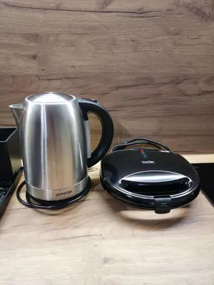 a silver and black appliance sitting on a wooden table at Apartman 
