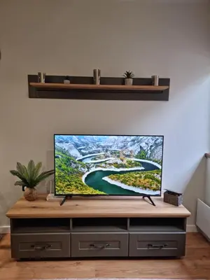 a flat screen tv sitting on top of a entertainment center at Apartman 