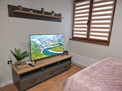 a bedroom with a flat screen tv on a dresser at Apartman 