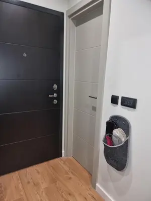a hallway with a black door and a room with a door gmaxwell gmaxwell at Apartman 