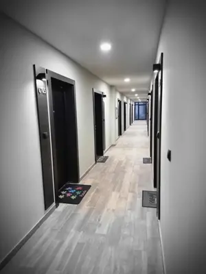 an empty hallway with a row of doors in a building at Apartman 