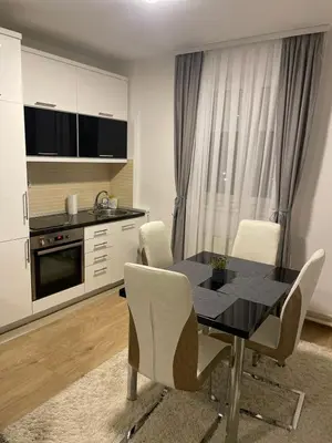 a kitchen with a dining room table and chairs at TRG In in Vrnjačka Banja