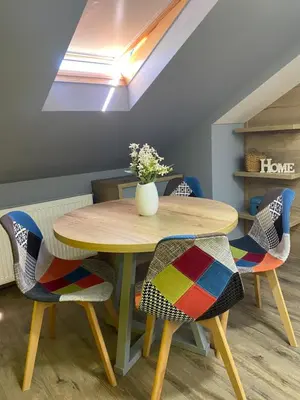 a dining room table with chairs and a vase on it at Iris Apartment in Vrnjačka Banja