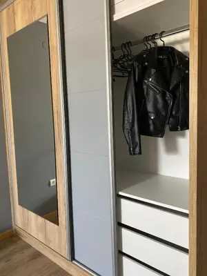 a mirror in a closet with a leather jacket at Iris Apartment in Vrnjačka Banja