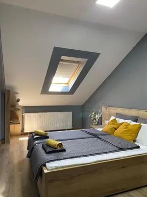 a bedroom with a large bed with yellow pillows at Iris Apartment in Vrnjačka Banja