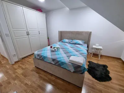 a bedroom with a bed with a plaid blanket at Silver city 2 in Jagodina