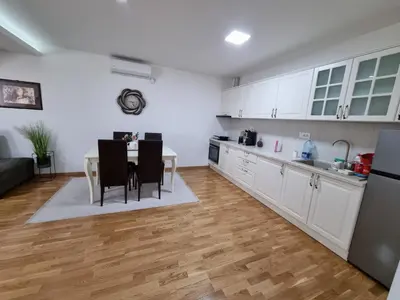 a kitchen with white cabinets and a table with chairs at Silver city 2 in Jagodina