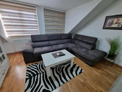 a living room with a leather couch and a table at Silver city 2 in Jagodina