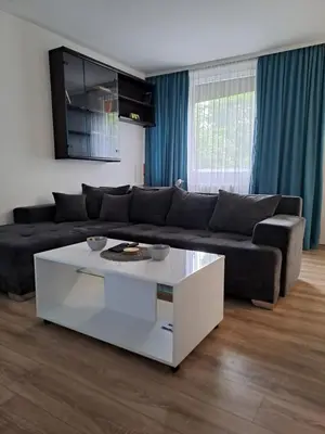 a living room with a black couch and a white coffee table at Delta 10 in Niš