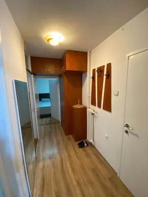 a room with a hallway with wooden floors and a door at Delta 10 in Niš