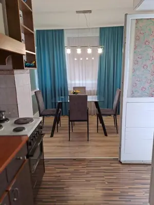 a kitchen and dining room with a table and chairs at Delta 10 in Niš