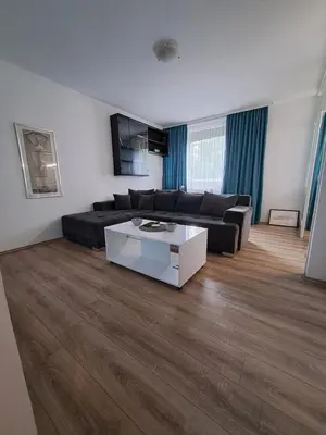 a living room with a black couch and a white table at Delta 10 in Niš
