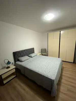 a bedroom with a bed and a table with a lamp at Delta 10 in Niš