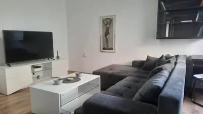 a living room with a couch and a flat screen tv at Delta 10 in Niš
