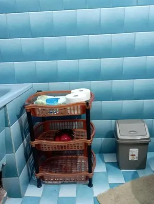 a shopping cart in a blue tiled bathroom at Apartman Miki Jovanović in Pirot