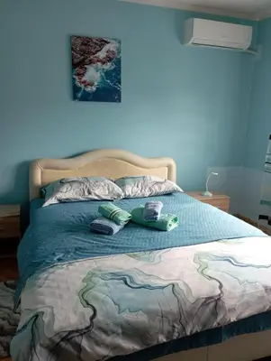 a bed with two slippers on top of it at Apartman Miki Jovanović in Pirot