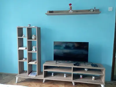 a entertainment center with a television and two shelves at Apartman Miki Jovanović in Pirot